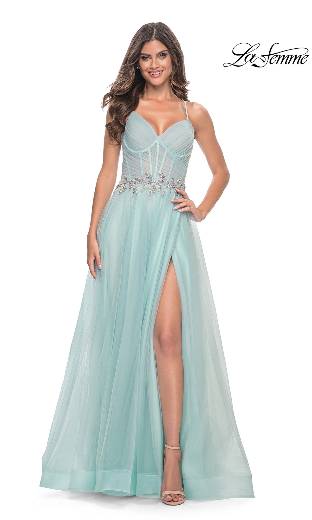 A woman poses against a white background in the La Femme Sheer-Bodice Long A-Line Prom Dress 32117, a light blue formal gown featuring strappy open back, sheer overlay, jeweled waist, and thigh-high slit. The